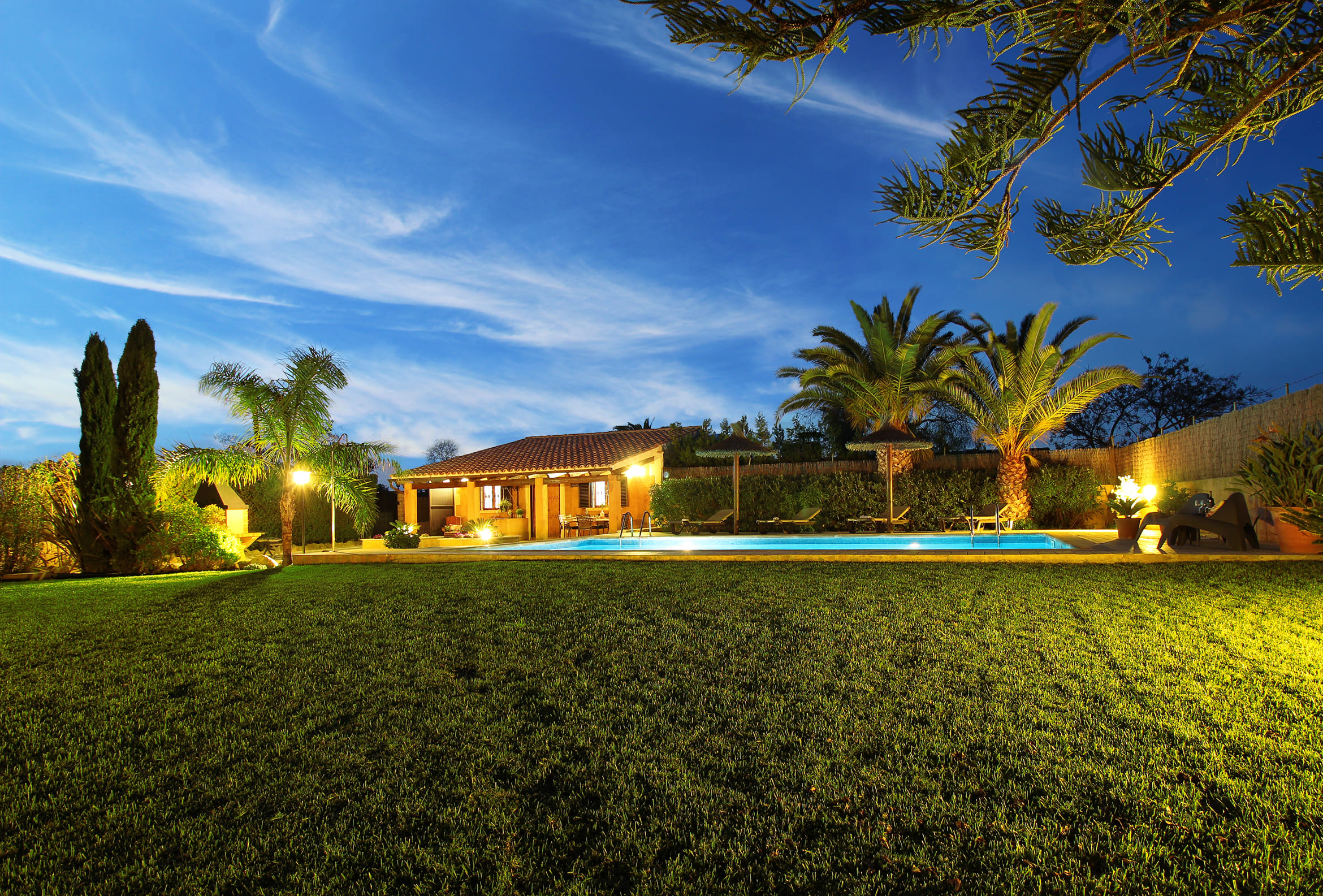 The villa softly lit at dusk
